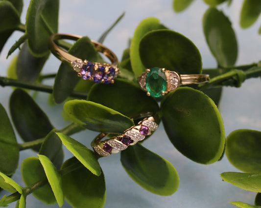 Three gold gemstone and diamond rings in a faux plant