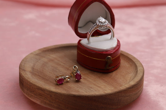 9ct White Gold & Diamond Set Teardrop Halo Ring in a red jewellery box with 9ct Yellow Gold Diamond & Ruby Set Stud Earrings