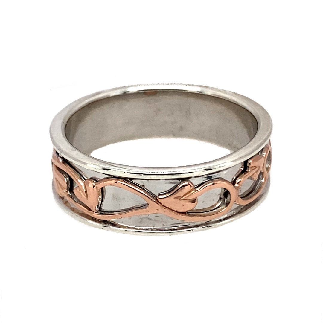 Bring rich symbolism and elegant contrast to your jewellery collection with this pre-owned 925 silver Clogau Tree of Life band ring, detailed with 9ct rose gold—perfect for meaningful style and everyday wear.
Design: The 7mm wide band features the iconic Tree of Life motif, with flowing vines in polished 9ct rose gold woven through the silver for a warm and graceful finish.