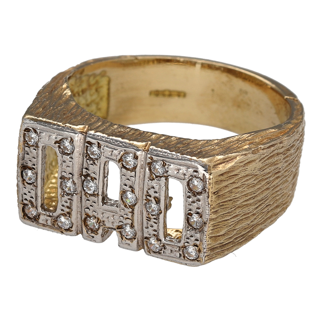 Bring bold contrast and meaningful sparkle to your collection with this new 9ct yellow gold and white gold Dad ring, set with cubic zirconia—a standout design that celebrates fatherhood with style and strength.
Design: The ring features a 12mm high front with the word "DAD" in raised yellow gold lettering set against a white gold background, accented with sparkling cubic zirconia for a striking two-tone look.