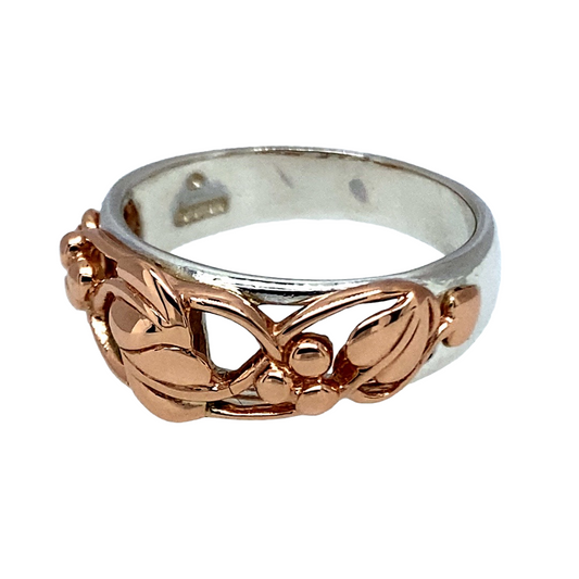 Bring meaningful elegance and heritage symbolism to your jewellery collection with this pre-owned 925 silver Clogau Tree of Life ring, featuring 9ct rose gold detailing—perfect for celebrating growth, connection, and timeless beauty.
Design: The ring features the iconic Tree of Life design across the front of the 8mm wide band, with flowing 9ct rose gold vines woven into the pattern for a graceful, layered effect.