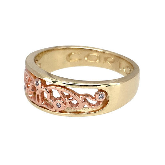 Preowned 9ct Yellow and Rose Gold & Diamond Set Clogau Open Patterned Wide Band Ring with Cariad inscribed inside the band. The ring is in size U with the weight 5.80 grams. The band is 8mm wide and the hallmarks inside the band are very worn