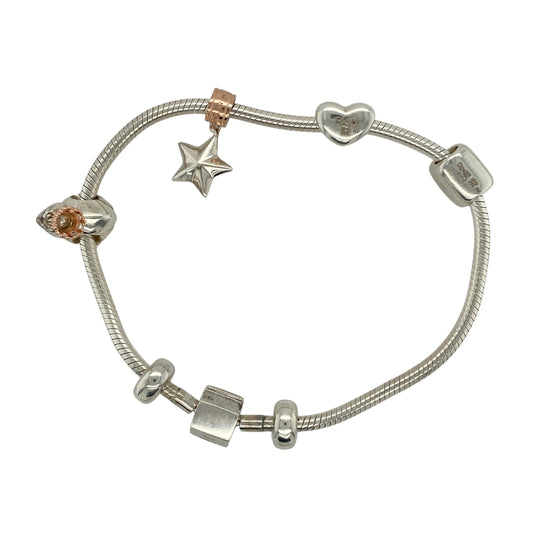 Bring playful elegance and meaningful detail to your collection with this pre-owned Clogau charm bracelet in silver, a versatile piece featuring a mix of symbolic charms.
Design: The 8-inch bracelet includes a Welsh dragon charm, a yellow enamel heart charm engraved with “Cariad” (the Welsh word for “Love”), a star, a frog prince, and two stoppers, offering both heritage symbolism and whimsical character.