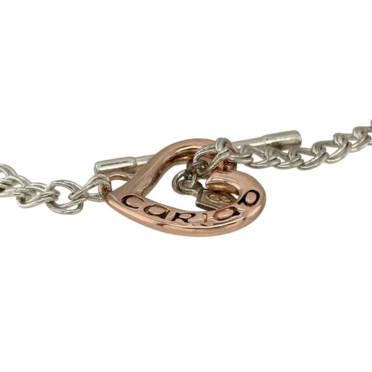 Bring romantic charm and timeless detail to your collection with this pre-owned Clogau double curb heart T-bar bracelet in silver and 9ct rose goldβa symbolic piece celebrating love and elegance.
Design: The bracelet features a 7-inch double curb chain with 4mm wide links, finished with a 17mm by 16mm heart inscribed with βCariad,β the Welsh word for βLove.β A classic T-bar clasp completes the design.