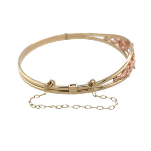 Preowned 9ct Yellow and Rose Gold Clogau Tree of Life Bangle with a safety chain with the weight 10.70 grams. The front of the ring is 11mm high and the bangle diameter is 6cm