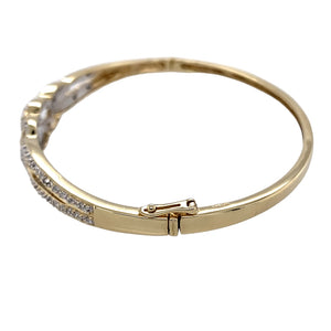 Preowned 9ct Yellow and White Gold & Diamond Set Celtic Knot Bangle with the weight 11.10 grams. There is approximately 10pt of diamond content set in the bangle in total. The bangle diameter is 6.5cm and the front of the bangle is 10mm high