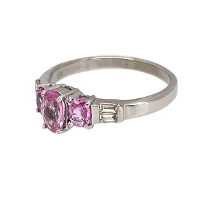 Preowned 9ct White Gold Diamond & Pink Sapphire Set Ring in size N with the weight 2.30 grams. The ring is made up with three oval cut pink sapphire stones are two baguette cut diamonds on either side. The center sapphire stone is 6mm by 4mm and the side stones are each 4mm by 3mm