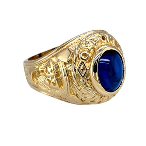 Preowned 9ct Yellow Gold & Blue Stone Set Oxford University College Style Ring in size R with the weight 11.60 grams. The blue stone is 9mm by 7mm and the front of the ring is 19mm high
