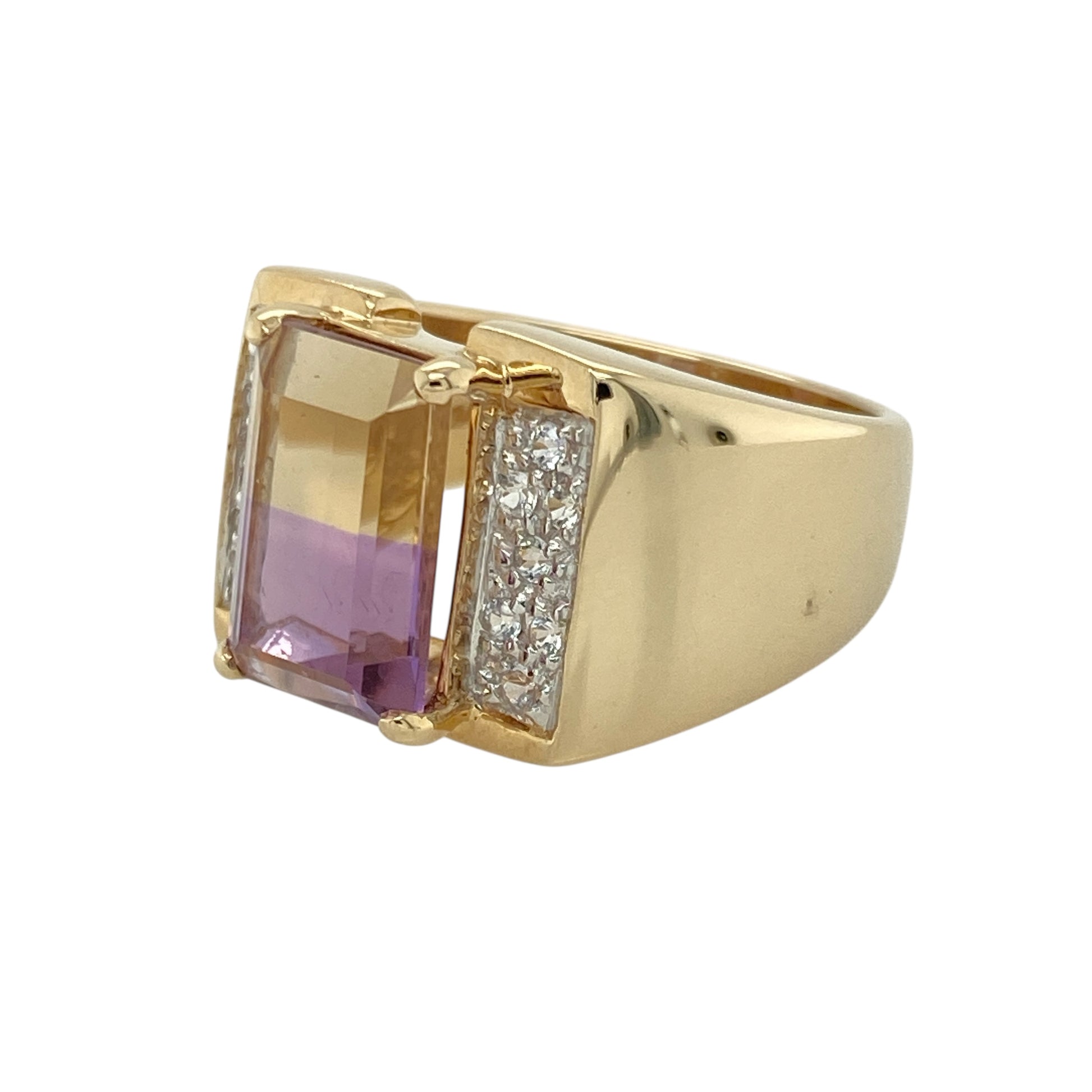 Bring striking colour and bold elegance to your collection with this pre-owned 9ct yellow gold ametrine and cubic zirconia ring—a distinctive design with eye-catching detail.
Design: The ring showcases a 12mm by 8mm rectangular ametrine stone at the centre, displaying its unique blend of purple and golden tones, accented by sparkling cubic zirconia for added brilliance.
Material: Made from 9-carat yellow gold, the polished finish enhances the warm hues of the ametrine and the sparkle of the cubic zirconia.