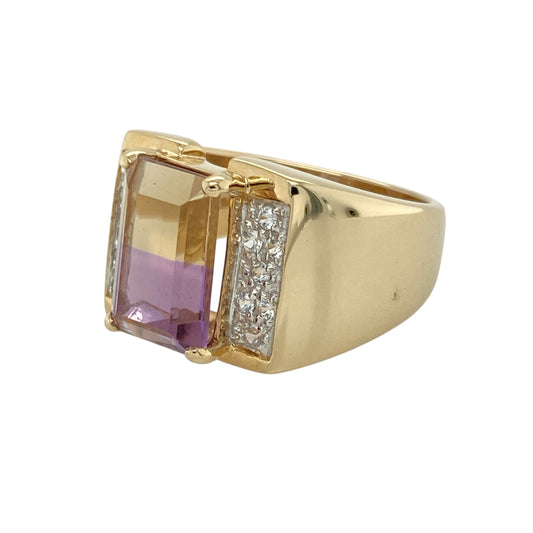 Bring striking colour and bold elegance to your collection with this pre-owned 9ct yellow gold ametrine and cubic zirconia ring—a distinctive design with eye-catching detail.
Design: The ring showcases a 12mm by 8mm rectangular ametrine stone at the centre, displaying its unique blend of purple and golden tones, accented by sparkling cubic zirconia for added brilliance.
Material: Made from 9-carat yellow gold, the polished finish enhances the warm hues of the ametrine and the sparkle of the cubic zirconia.