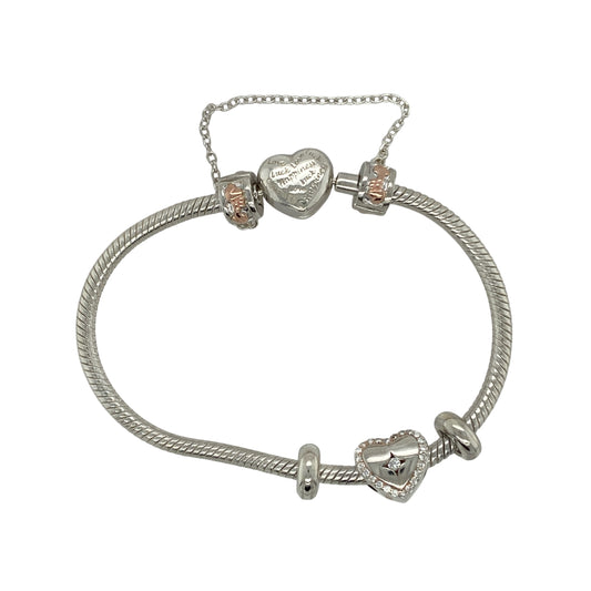 Bring romance and elegant sparkle to your collection with this pre-owned Clogau heart charm bracelet in silver, 9ct rose gold, and white topazβa meaningful design full of sentiment and style.
Design: The bracelet features a heart-shaped charm set with sparkling white topaz stones, complemented by a heart-shaped clasp engraved with βCariad,β the Welsh word for βLove.β