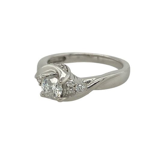 Bring modern elegance and graceful sparkle to your collection with this pre-owned 9ct white gold diamond twist solitaire ring—a timeless piece with a contemporary touch.
Design: The ring features a central diamond surrounded by smaller diamonds that accentuate its brilliance, creating a total diamond content of approximately 0.28ct. The elegant twist design gives the ring fluid movement and a romantic sense of unity.