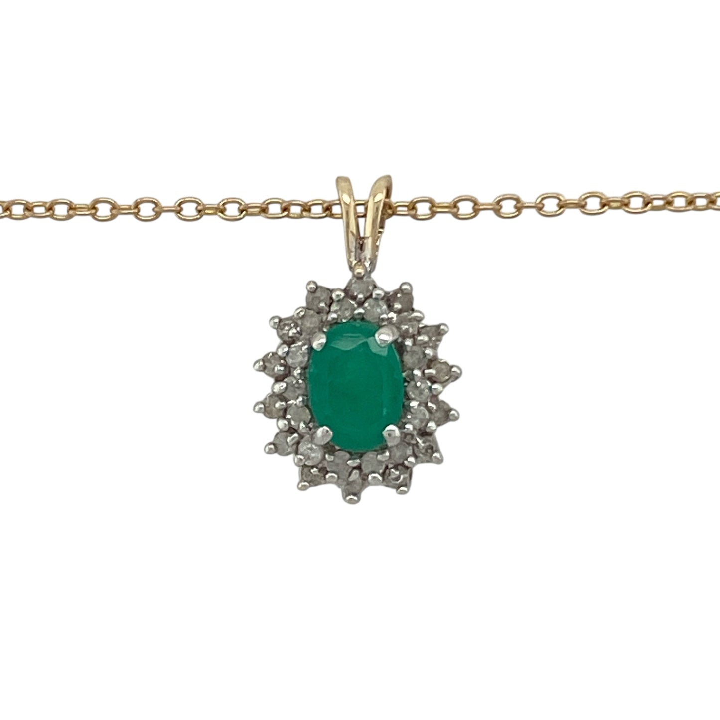 Bring vibrant colour and timeless elegance to your collection with this pre-owned 9ct yellow gold diamond and emerald cluster pendant on a 20" chain necklace—a beautifully classic design that radiates sophistication and charm.
Design: The pendant features a stunning oval-cut emerald at the centre, measuring approximately 7mm by 5mm, surrounded by a sparkling halo of diamonds that enhance the rich green hue of the gemstone.