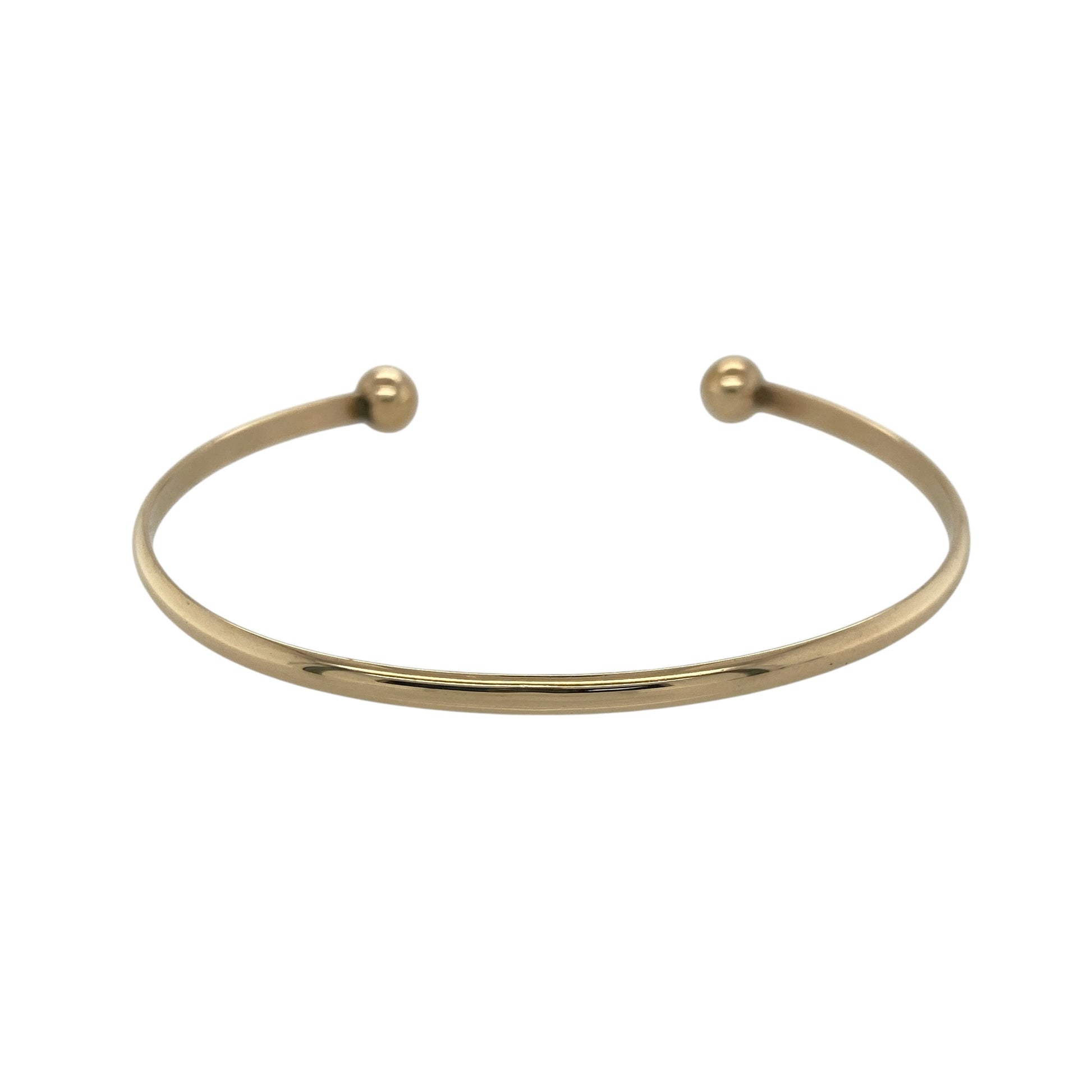 Bring sleek style and classic elegance to your collection with this pre-owned 9ct solid yellow gold torque bangle—perfect for everyday wear or adding a timeless finishing touch to any outfit.
Design: The bangle features a smooth 3mm-wide band finished with two 6mm polished gold balls at each end, creating the signature open torque style. Its simple yet sophisticated design offers versatility and enduring appeal.