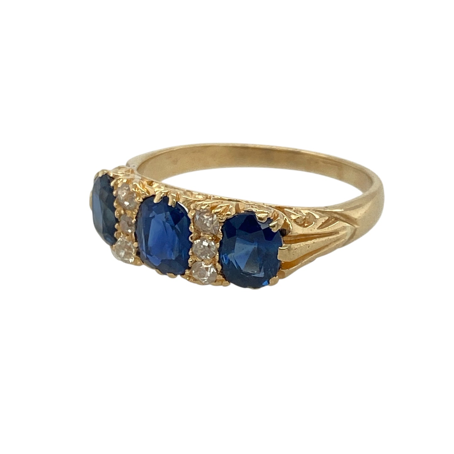 Add vintage charm and timeless sophistication to your collection with this pre-owned 18ct yellow gold diamond and sapphire set ring — a beautifully balanced design that embodies classic elegance.
Design: The ring features an oval-cut sapphire at the centre measuring approximately 6mm by 4mm, flanked by two 5mm by 4mm sapphires on either side. Three sparkling diamonds are set in between the stones, adding brilliance and enhancing the deep blue tones of the sapphires.