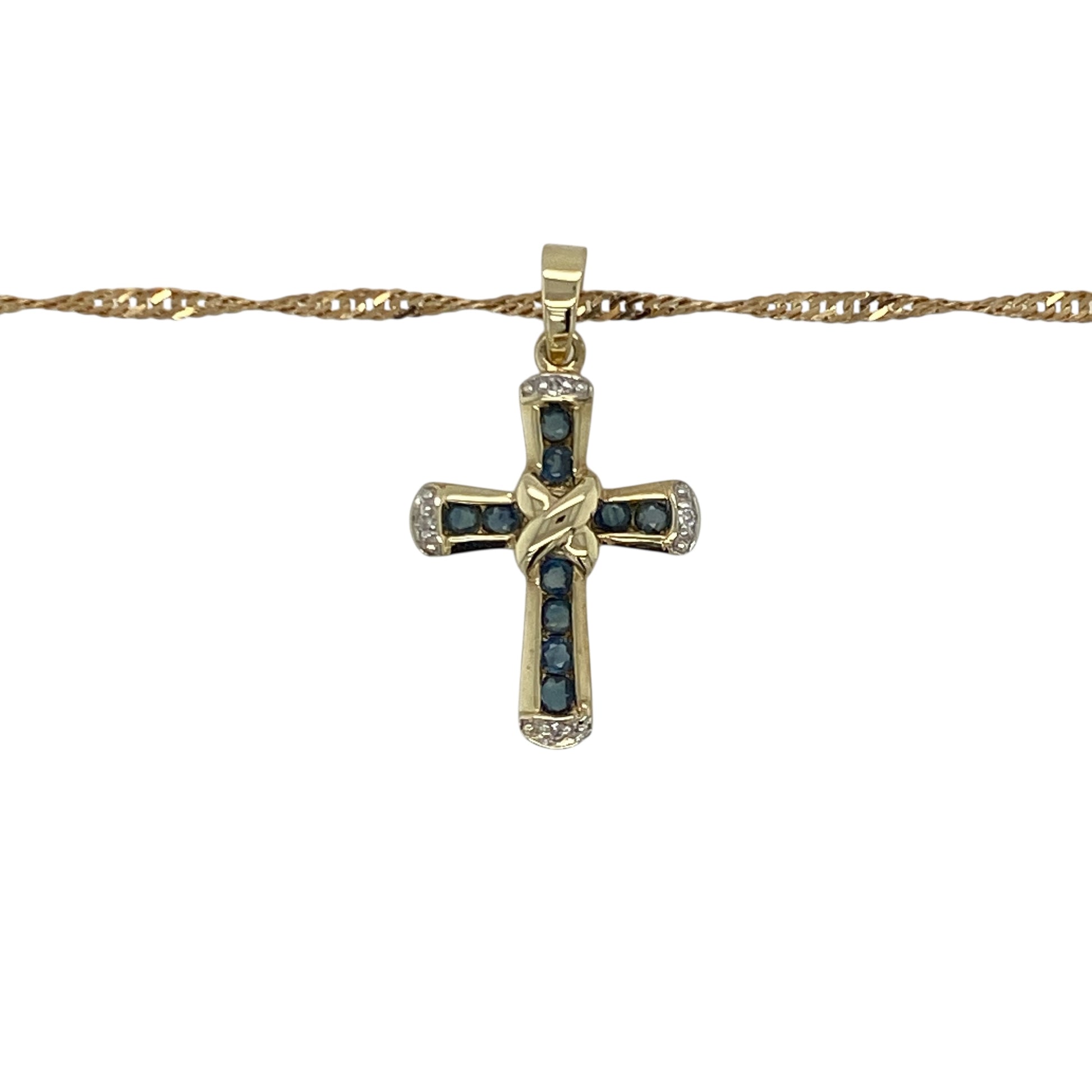 Add timeless beauty and classic sparkle to your collection with this pre-owned 9ct yellow gold diamond and sapphire set cross pendant on an 18" Singapore chain necklace — a refined piece that blends faith and elegance.
Design: The pendant features a delicate cross adorned with rich blue sapphires and sparkling diamonds, creating a graceful balance of colour and brilliance. Measuring 2.5cm long including the bail, it offers a subtle yet eye-catching presence.