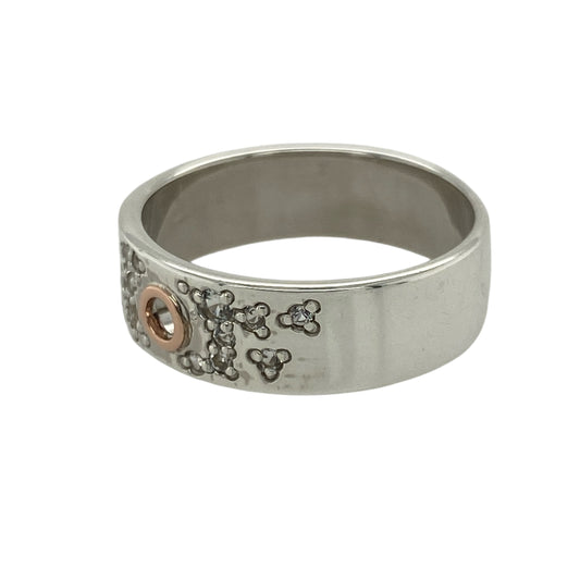 Add modern elegance and subtle sparkle to your collection with this pre-owned 925 silver and 9ct rose gold Clogau band ring, blending contemporary design with timeless craftsmanship—perfect for everyday wear or understated sophistication.
Design: The ring features a 7mm wide band with scattered white topaz stones that shimmer delicately across the surface. A distinctive round cut-out detail at the centre adds a unique and artistic touch to the design.