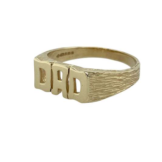 Celebrate sentiment and classic style with this pre-owned 9ct yellow gold Dad ring, a timeless piece that combines bold design with meaningful charm—perfect as a treasured keepsake or thoughtful gift.
Design: The ring features the word DAD across the front, measuring 8mm high, with textured shoulders that add depth and character to the design.
Material: Made from 9-carat yellow gold, the polished finish enhances the warm tone of the metal and gives the piece a refined yet masculine look.