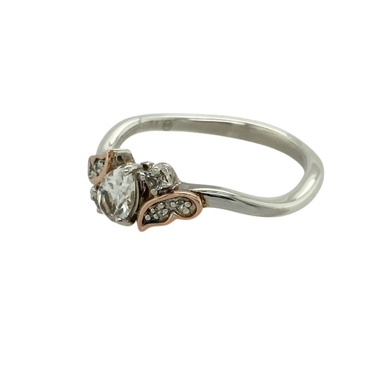 Bring graceful sparkle and contemporary elegance to your collection with this pre-owned 925 silver with 9ct rose gold and white topaz set Clogau teardrop ring—a beautifully feminine design inspired by timeless sophistication.
Design: The ring features a 6mm by 4mm teardrop-shaped white topaz at the centre, radiating brilliance and complemented by Clogau’s signature rose gold detailing.