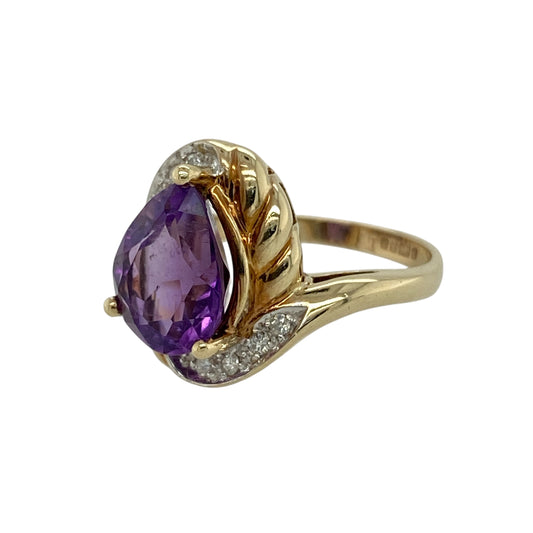 Bring rich colour and elegant sparkle to your jewellery collection with this pre-owned 9ct yellow gold diamond and amethyst set ring, a striking design with graceful presence and timeless appeal.
Design: The ring features a teardrop-shaped amethyst as the focal point, measuring approximately 10mm by 8mm, offering vivid purple colour and an elegant silhouette. Diamond accents add subtle brilliance, enhancing the beauty of the centre stone.