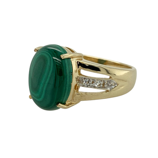 Bring bold natural beauty and refined sparkle to your jewellery collection with this pre-owned 9ct yellow gold malachite & white topaz set ring, a striking design with rich colour and elegant detail.
Design: The ring features an oval malachite stone measuring 13mm by 10mm, showcasing distinctive green banding and natural character, surrounded by white topaz stones that add radiant sparkle and definition.
