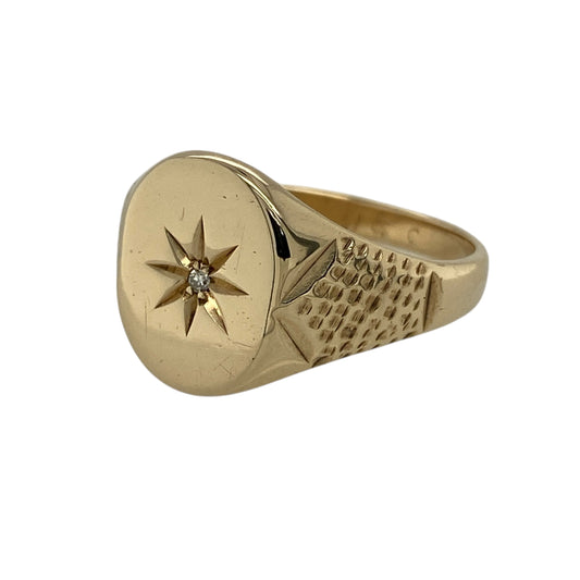 Bring bold character and striking sparkle to your jewellery collection with this pre-owned 9ct yellow gold diamond starburst set signet ring.
Design: The ring features a standout starburst motif set with a sparkling diamond at the centre, creating a strong and eye-catching focal point. The front of the ring measures approximately 14mm in height, giving it a commanding presence.
Material: Made from 9-carat yellow gold, the warm polished finish enhances the dramatic starburst design and classic signet style.