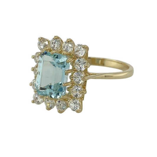 Bring fresh colour and elegant sparkle to your jewellery collection with this pre-owned 9ct gold aquamarine and cubic zirconia set cluster ring, offering a refined design with a striking centre stone—perfect for special occasions or standout everyday wear.
Design: The ring features a rectangular aquamarine stone at the centre measuring approximately 9mm by 6mm, surrounded by cubic zirconia in a classic cluster arrangement that enhances brilliance and presence.