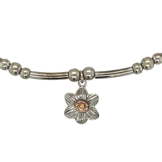 Bring symbolic charm and elegant contrast to your collection with this pre-owned Clogau daffodil stretchy affinity braceletβan attractive piece offering Welsh heritage and refined feminine style.
Design: This bracelet features a flexible stretchy band adorned with a 9mm daffodil charm, celebrating the national flower of Wales with delicate, detailed craftsmanship.