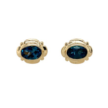 Load image into Gallery viewer, Preowned 9ct Yellow Gold &amp; Blue Topaz Oval Stud Earrings with the weight 1.70 grams. The blue topaz stones are each 7mm by 5mm
