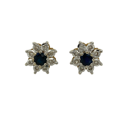 Bring classic colour and elegant sparkle to your jewellery collection with these pre-owned 9ct yellow gold diamond and sapphire set cluster stud earrings.
Design: The earrings feature rich blue sapphire centre stones, each measuring approximately 4mm in diameter, surrounded by a halo of sparkling diamonds to create a timeless cluster style.
Material: Made from 9-carat yellow gold, the warm polished finish beautifully complements the deep blue of the sapphires and the brilliance of the diamonds.