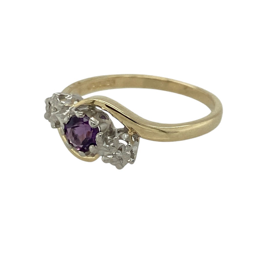 Add graceful colour and elegant sparkle to your jewellery collection with this pre-owned 9ct yellow gold diamond and amethyst trilogy twist ring, offering a refined design with timeless appeal.
Design: This ring features a trilogy-style arrangement with a round amethyst at the centre measuring approximately 4mm in diameter, framed by illusion-style diamonds on either side for enhanced sparkle and balance. The gentle twist design adds movement and elegance to the overall look.