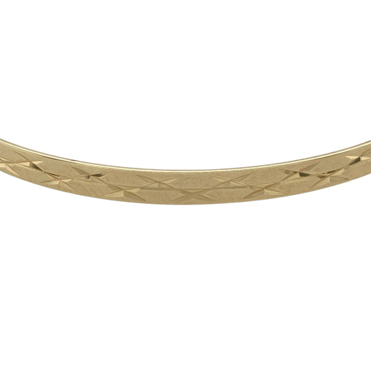 Add refined sparkle to your jewellery collection with this pre-owned 9ct yellow solid gold diamond cut patterned bangle, combining classic style with light-catching detail. A timeless piece ideal for everyday wear or elegant layering.
Design: Measuring approximately 4mm in width, the bangle features a diamond cut patterned finish that creates a faceted surface, reflecting light beautifully with every movement. The slim yet defined profile offers a balanced and sophisticated look on the wrist.