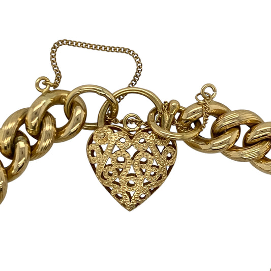 Make a bold and timeless statement with this pre-owned 18ct yellow gold open patterned heart padlock curb charm bracelet, combining classic design with substantial weight and luxurious appeal. A standout piece perfect for everyday elegance or special occasions.
Design: The bracelet features a traditional 7" curb link design measuring approximately 10mm in width, creating a strong and eye-catching profile on the wrist.