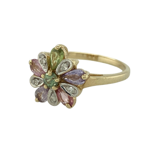 Add vibrant colour and floral elegance to your jewellery collection with this pre-owned 9ct yellow gold diamond and gemstone set flower cluster ring, a striking statement piece perfect for special occasions or brightening everyday wear.
Design: The ring features a beautifully arranged flower cluster design measuring approximately 12mm high at the front.