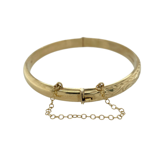 Add timeless elegance to your jewellery collection with this pre-owned 9ct yellow gold patterned hinged bangleβan eye-catching piece perfect for everyday wear or special occasions.
Design: The bangle measures approximately 7mm wide and features a decorative patterned finish, adding texture and visual interest across the surface. The classic oval shape with a 6cm diameter offers a comfortable and flattering fit on the wrist.