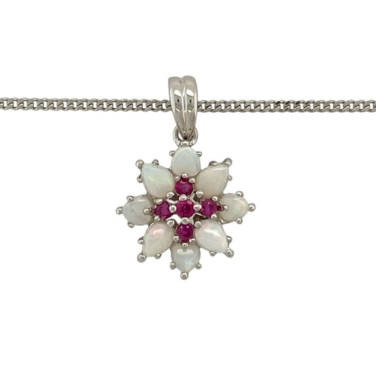Bring delicate colour and vintage-inspired charm to your jewellery collection with this pre-owned 9ct white gold opal and ruby flower pendant, complete with an 18" curb chain necklace—perfect for adding a soft yet vibrant touch to any outfit.
Design: This eye-catching flower pendant features a central opal surrounded by rich red ruby accents, forming an elegant floral cluster design.