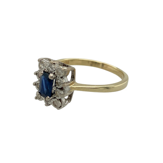 Add timeless colour and elegant sparkle to your jewellery collection with this pre-owned 9ct yellow gold diamond and sapphire cluster ring, featuring classic gemstones and a refined design—perfect for everyday wear or special occasions.
Design: The ring showcases an oval sapphire at the centre measuring approximately 6mm by 4mm, surrounded by a cluster of sparkling diamonds that enhance the deep blue colour of the gemstone. The cluster layout creates a balanced and eye-catching focal point.