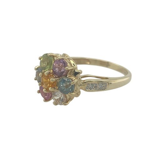 Add vibrant colour and elegant sparkle to your jewellery collection with this pre-owned 9ct yellow gold diamond and multi coloured topaz flower ring, featuring a lively floral designβperfect for making a statement or brightening everyday wear.
Design: The ring showcases a flower cluster design set with multi coloured topaz gemstones, each measuring approximately 3mm, accented by sparkling diamonds. The floral arrangement creates a balanced and eye-catching focal point with a mix of bright tones.