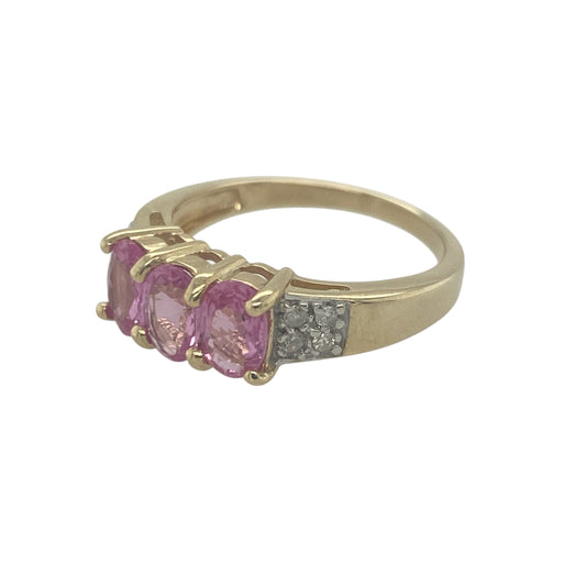Add soft colour and timeless elegance to your jewellery collection with this pre-owned 9ct yellow gold diamond and pink sapphire trilogy ring, featuring a classic three-stone design with delicate sparkleβperfect for everyday wear or meaningful gifting.
Design: The ring showcases a trilogy arrangement with a central pink sapphire measuring approximately 6mm by 4mm, flanked by sparkling diamonds.
