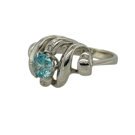 Add flowing elegance and vibrant colour to your jewellery collection with this pre-owned 18ct white gold diamond and blue topaz set wave style ring—an eye-catching piece perfect for special occasions or everyday wear.
Design: This ring features a graceful wave-style design, centred with a round blue topaz measuring approximately 6mm in diameter, complemented by sparkling diamonds that enhance the fluid and contemporary look.