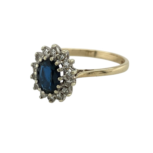 Add timeless elegance and rich colour to your jewellery collection with this pre-owned 9ct yellow gold diamond and sapphire set cluster ring—an eye-catching piece perfect for everyday wear or special occasions.
Design: This ring features a central oval sapphire measuring approximately 7mm by 5mm, surrounded by sparkling diamonds that create a classic and radiant cluster design.