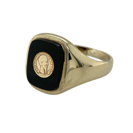 Add a bold yet classic touch to your jewellery collection with this pre-owned 9ct yellow gold onyx signet ring, featuring a distinctive centre detail and timeless styling—ideal for everyday wear or statement occasions.
Design: The ring features a rounded rectangular onyx measuring approximately 12mm by 10mm, with a 6mm coin detail set at the centre, creating a unique and eye-catching focal point.