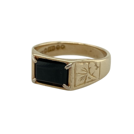 Add classic style with a touch of detail to your jewellery collection with this pre-owned 9ct yellow gold onyx signet ring, featuring a sleek design and decorative shoulders—perfect for everyday wear or a refined statement look.
Design: The ring showcases a rectangular onyx stone measuring approximately 8mm by 5mm, offering a smooth polished surface with deep black tones for a timeless appearance.