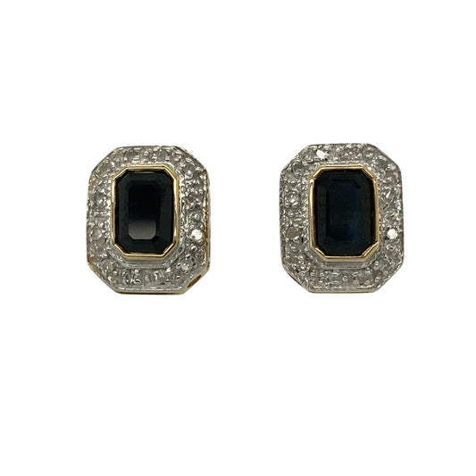 Add elegant colour and timeless sparkle to your collection with these pre-owned 9ct yellow and white gold diamond and sapphire set halo stud earringsβan eye-catching pair with classic appeal.
Design: The earrings feature rectangular sapphire gemstones, each measuring approximately 6mm by 4mm, surrounded by a halo of sparkling diamonds that enhance their deep blue tone and create a bright, refined finish.