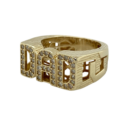 Celebrate family and style with this pre-owned 9ct yellow gold cubic zirconia set Dad signet ring—an eye-catching and meaningful piece with timeless appeal.
Design: The ring features a bold signet face measuring approximately 11mm in height, showcasing a “Dad” motif accented with sparkling cubic zirconia for added brilliance. The shoulders are styled in an open curb link design, adding texture and distinctive detail.