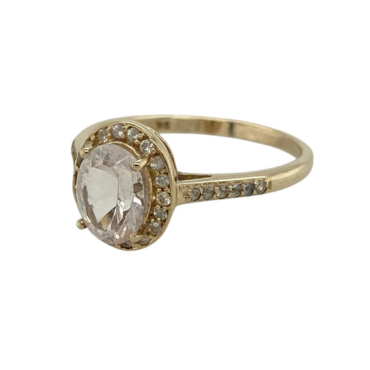 Add a pop of colour and elegant sparkle to your collection with this pre-owned 9ct yellow gold pink stone and cubic zirconia set halo ring—an eye-catching piece with timeless appeal.
Design: The ring features an 8mm by 6mm oval pink centre stone, surrounded by a halo of sparkling cubic zirconia, with additional stones set along the shoulders for extra brilliance.