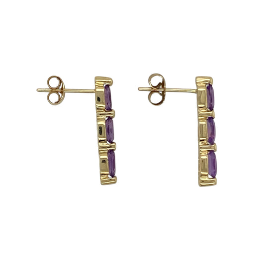 Bring rich colour and modern elegance to your collection with these pre-owned 9ct yellow gold amethyst three stone bar stud earrings, featuring a sleek linear design and vibrant gemstones—perfect for everyday wear or adding a touch of colour to any outfit.
Design: The earrings feature three oval amethyst stones arranged in a vertical bar formation, each measuring approximately 5mm by 3mm, creating a clean and contemporary look with balanced symmetry.