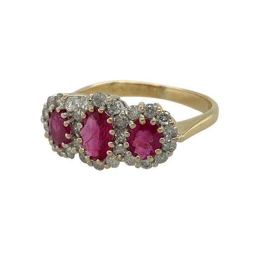 Bring rich colour and luxurious sparkle to your collection with this pre-owned 18ct yellow gold diamond and ruby trilogy cluster ring, featuring a striking multi-stone design with timeless appeal—perfect for special occasions or standout everyday wear.
Design: The ring showcases three oval rubies in a classic trilogy formation, with the centre stone measuring approximately 6mm by 4mm and the side stones each 5mm by 4mm, all surrounded by sparkling diamonds to create a bold and eye-catching cluster effect.