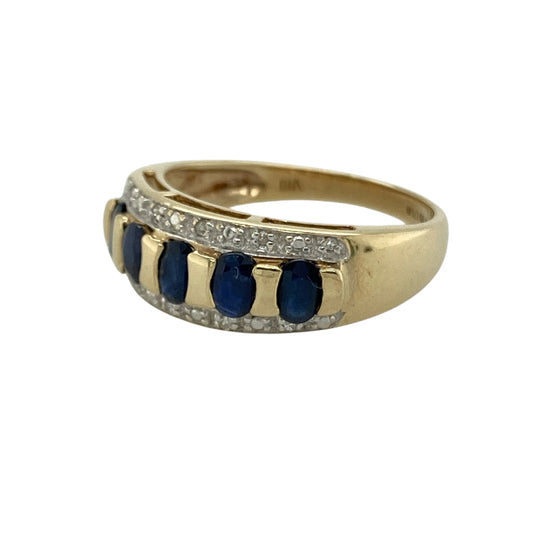 Bring timeless colour and elegant sparkle to your collection with this pre-owned 9ct yellow gold diamond and sapphire set band ring, featuring a bold design with classic appeal—perfect for everyday wear or special occasions.
Design: The ring features a band style with a front width of approximately 7mm, set with five oval sapphire stones measuring around 4mm by 2mm, accented by sparkling diamonds for added brilliance.
