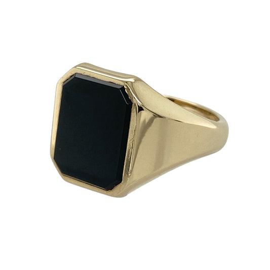 Add bold vintage-inspired style to your jewellery collection with this pre-owned 9ct yellow gold onyx set signet ring, featuring a striking rectangular black onyx stone with timeless statement appeal—perfect for everyday wear, formal occasions, or classic jewellery styling.
Design: The ring showcases a polished rectangular onyx stone measuring approximately 13mm by 10mm, creating a bold and eye-catching focal point within the traditional signet ring design.